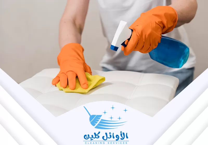 عامل يقوم بتنظيف الكنب باستخدام مواد تنظيف وتعقيم وممسح