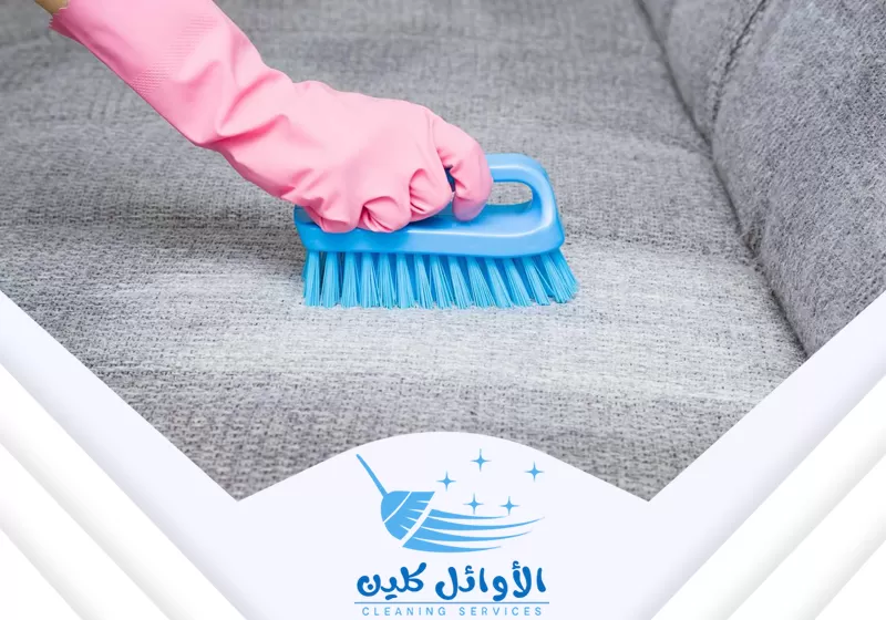 فني يقوم بتنظيف الكنب باستخدام فرشاة تنظيف الكنب